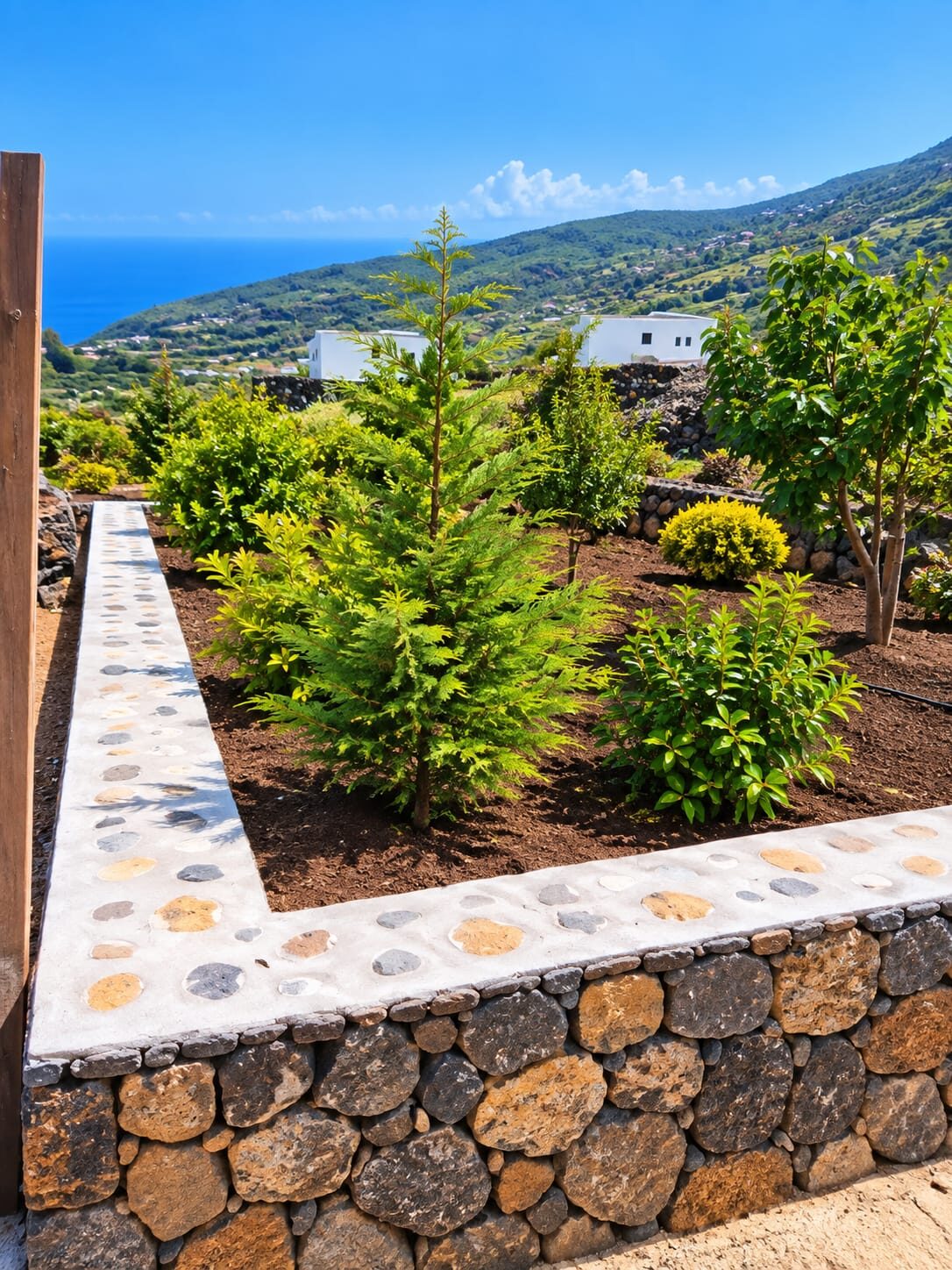 Jardineria, muro de piedra y camino con vistas al mar en La Palma
